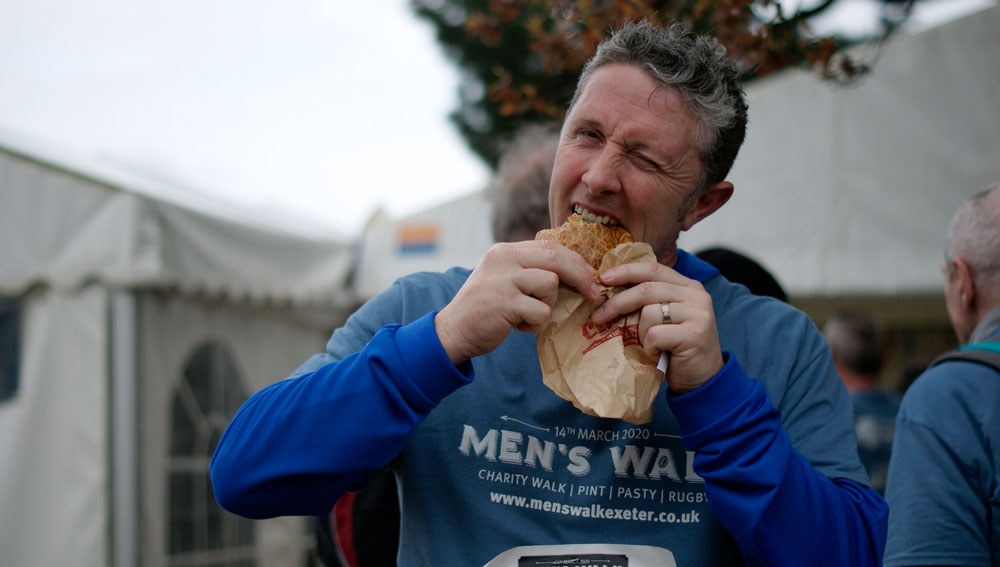 A man eating a Chunk pasty at the Hospiscare Men's Walk