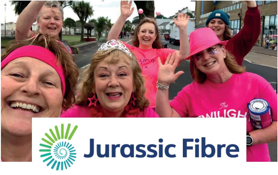 Women waving wearing pink t-shirts with Jurassic Fibre logo overlaid