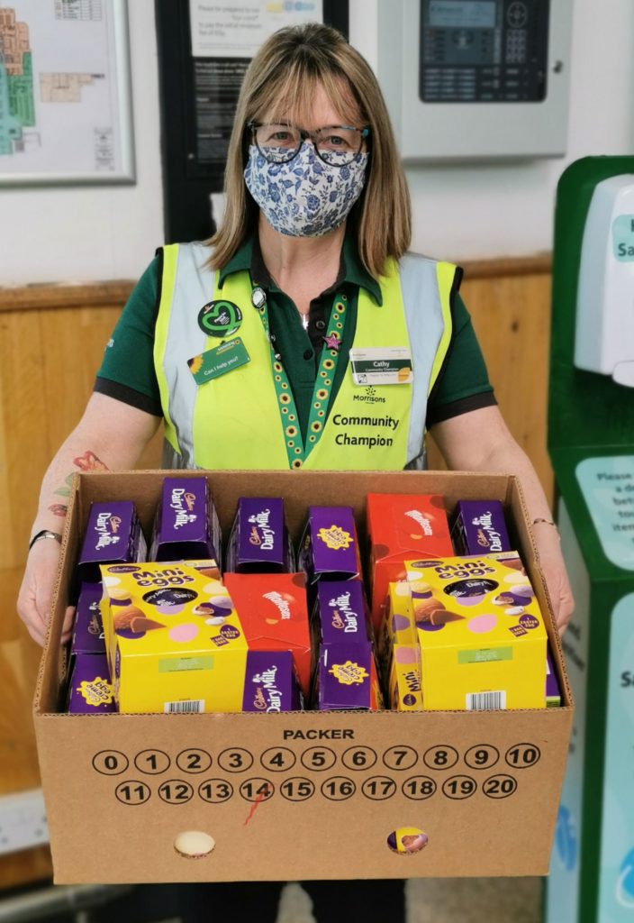 A Morrisons worker holding a box of Easter Eggs