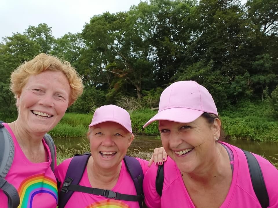Three women outside wearing pink