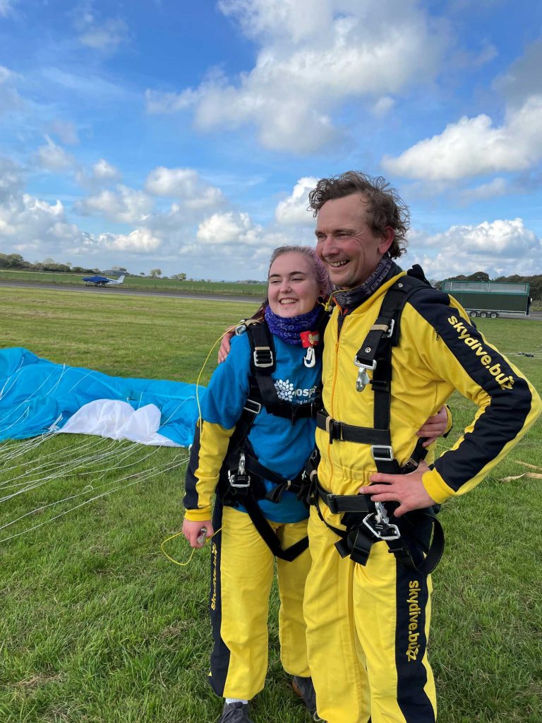 A young woman and man in flight suits after a skydive