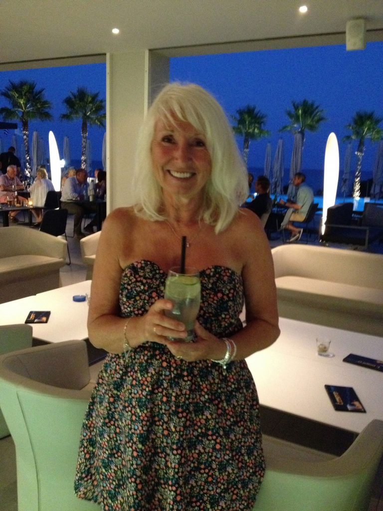 A woman in a holiday resort holding a drink