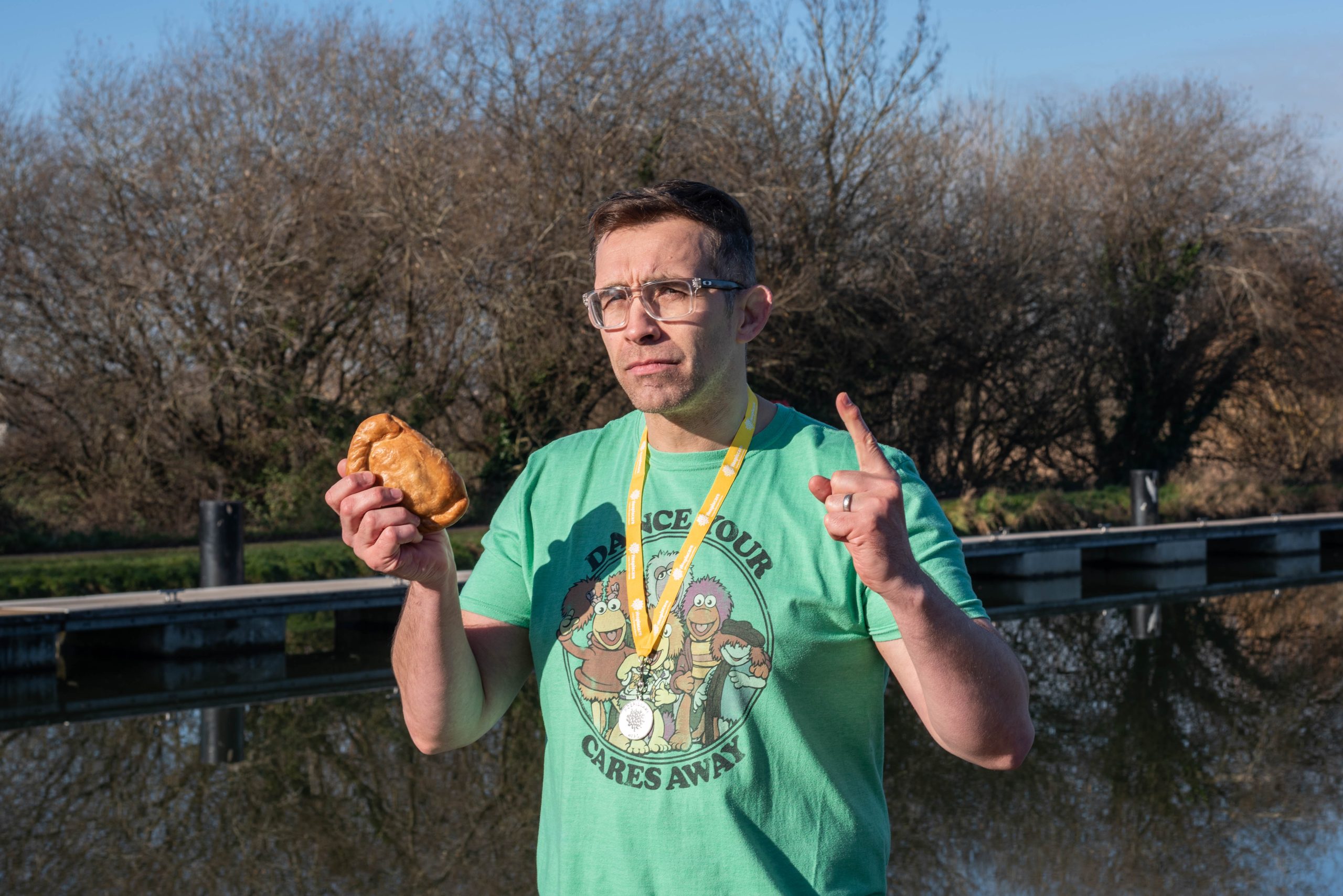 A man holding a pasty wearing a medal