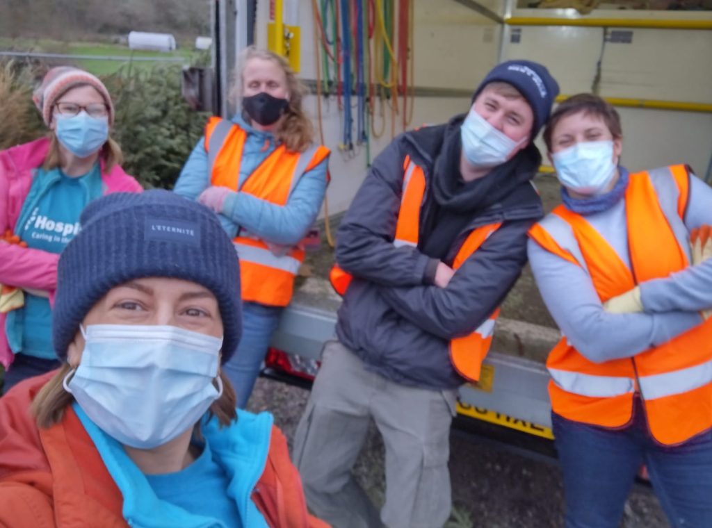 A group of people wearing face masks and high vis jackets