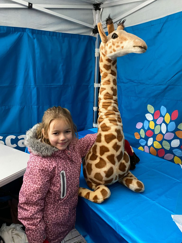 A young girl with a toy giraffe