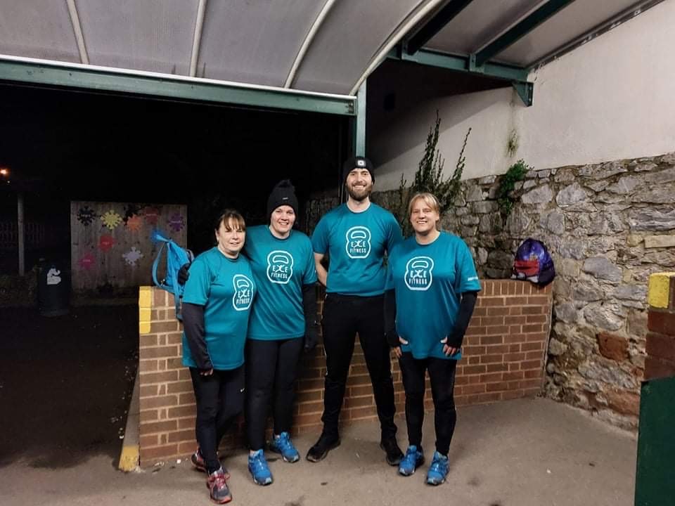 Four people wearing matching Exe Fitness exercise gear