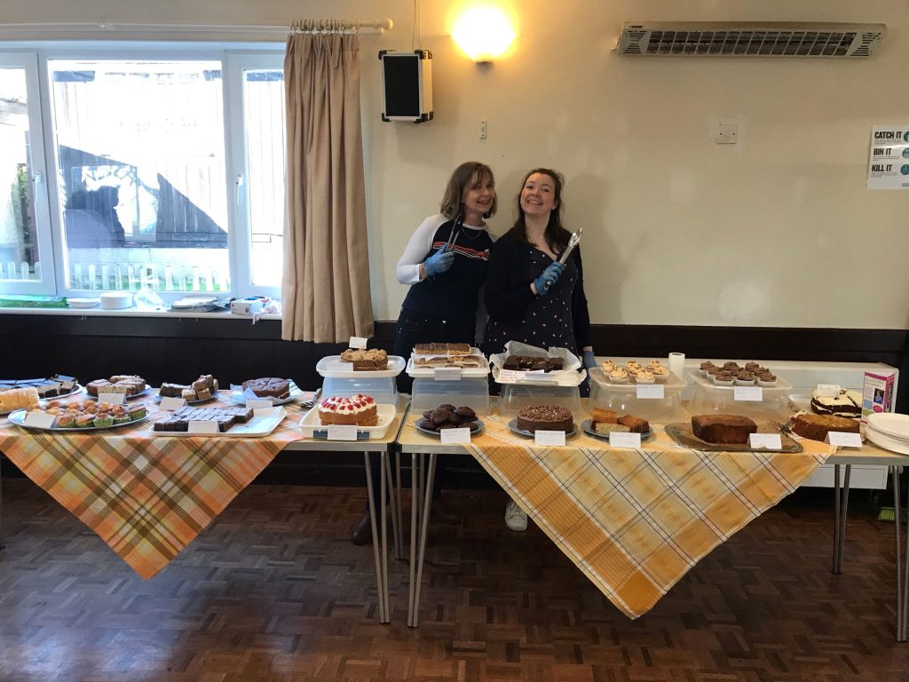 Two women behind a cake table