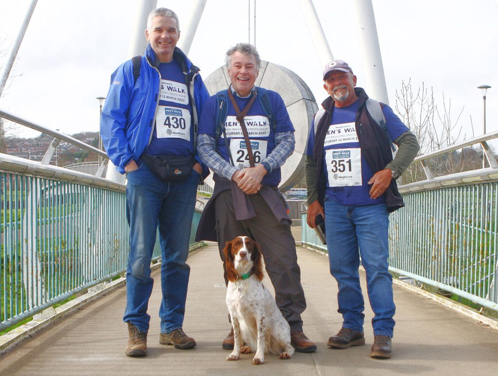 Three men and a springer spaniel on a bridge