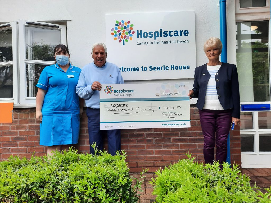 A man and a woman holding a big cheque with a Hospiscare nurse