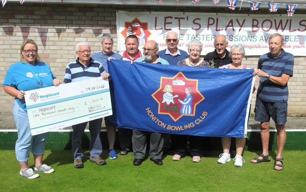 A group of people holding a big cheque and bowling club banner