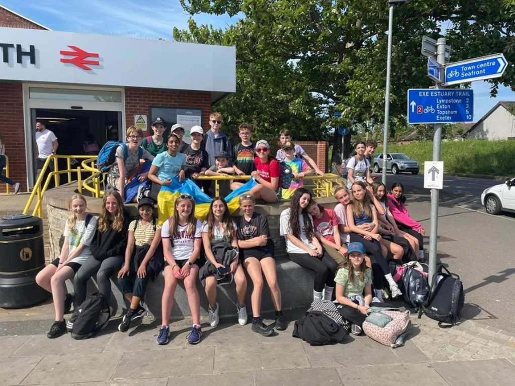 A group of young people outside a train station