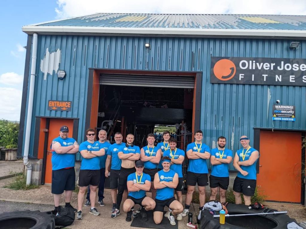 A group of men in exercise gear outside a gym