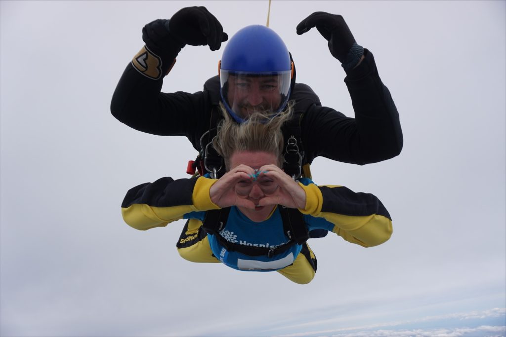 A woman and man mid-air in a tandem skydive