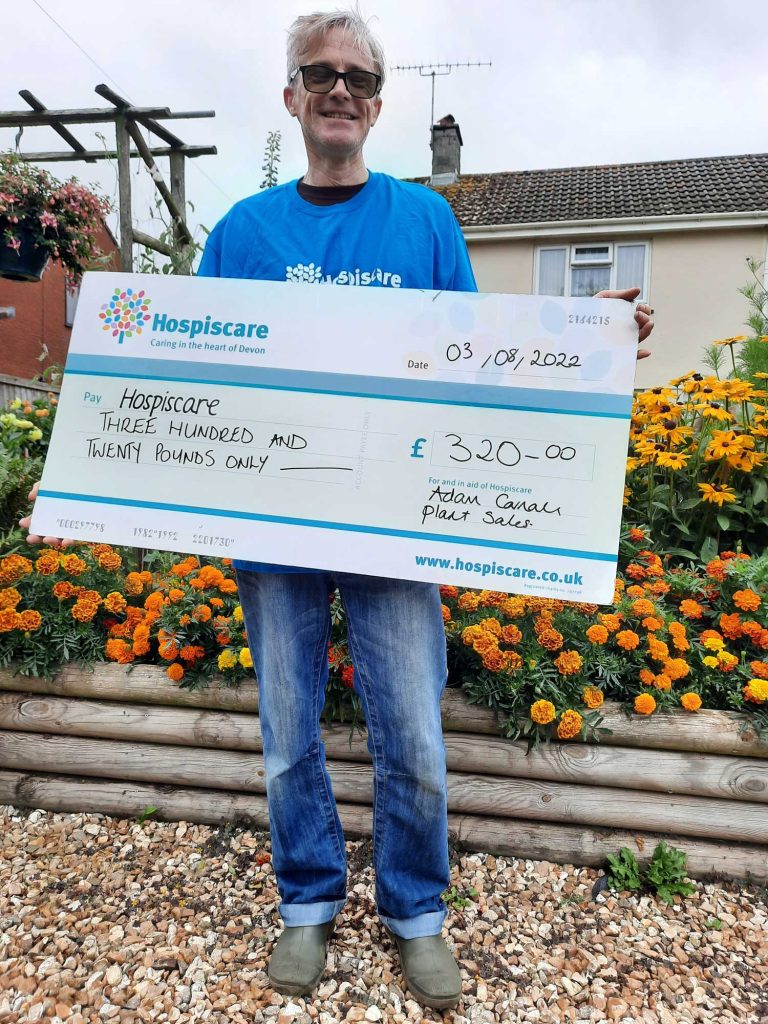 A man holding a big cheque for Hospiscare