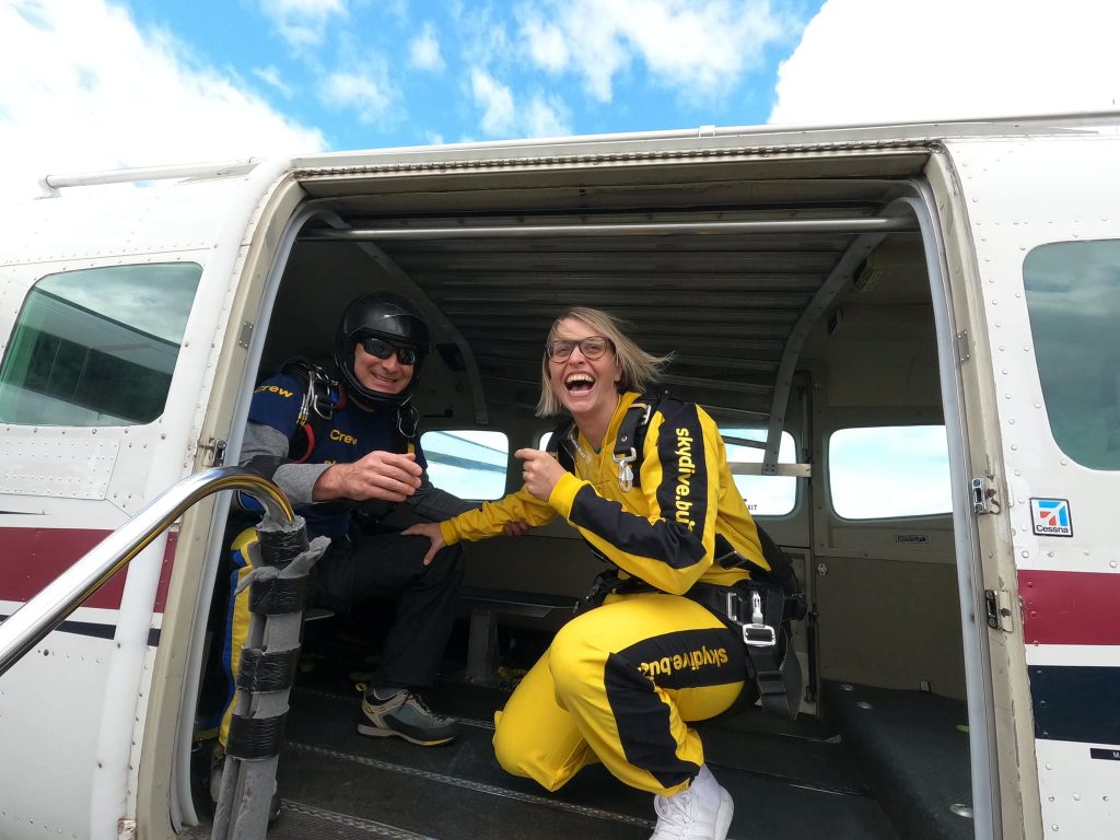 A man and woman laughing inside a small plane