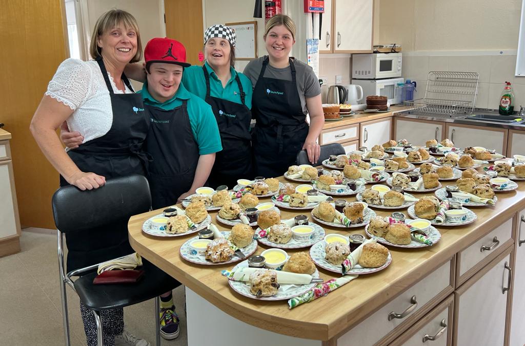 A group of people in a kitchen with homemade cream teas