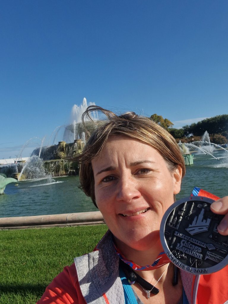 A selfie of a woman holding up a medal