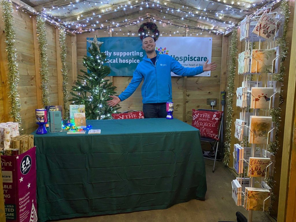 A man at a stall in a Christmas market hut