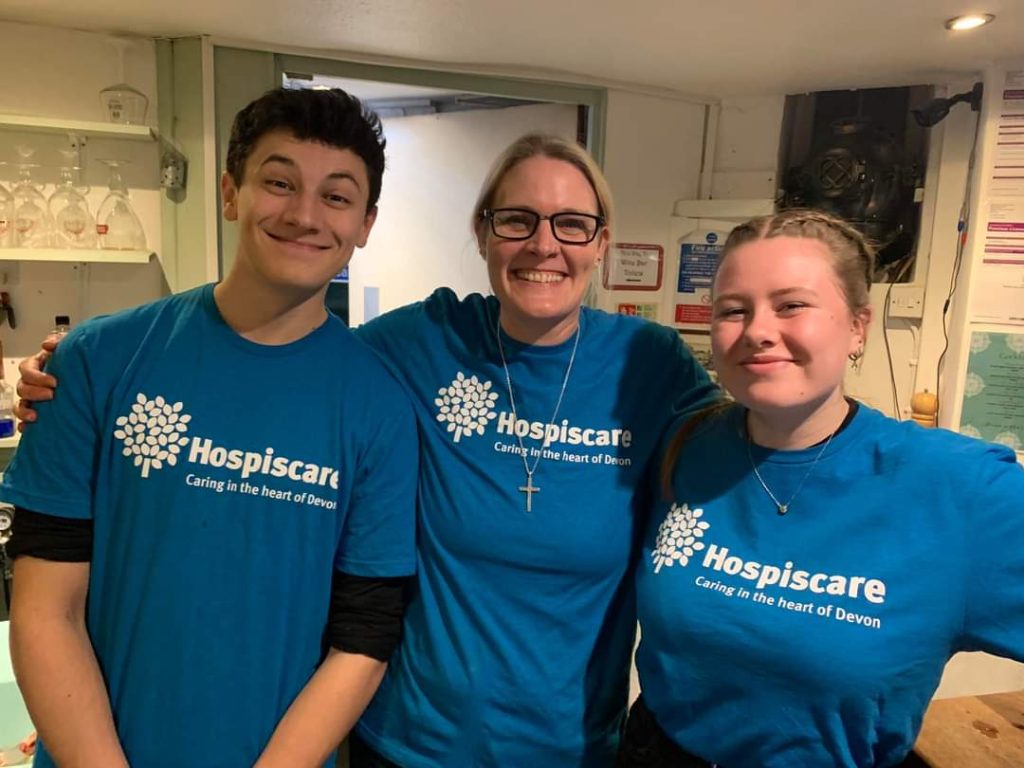 Three people wearing Hospiscare t-shirts smiling at the camera