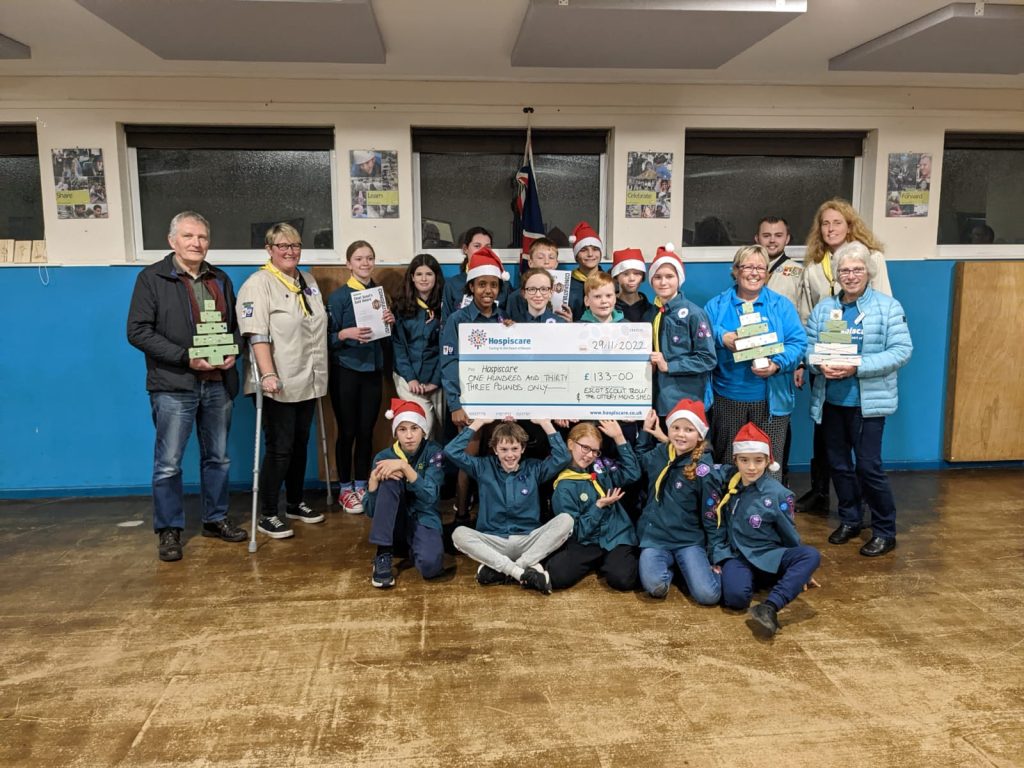 A group of scouts and adults with a big cheque
